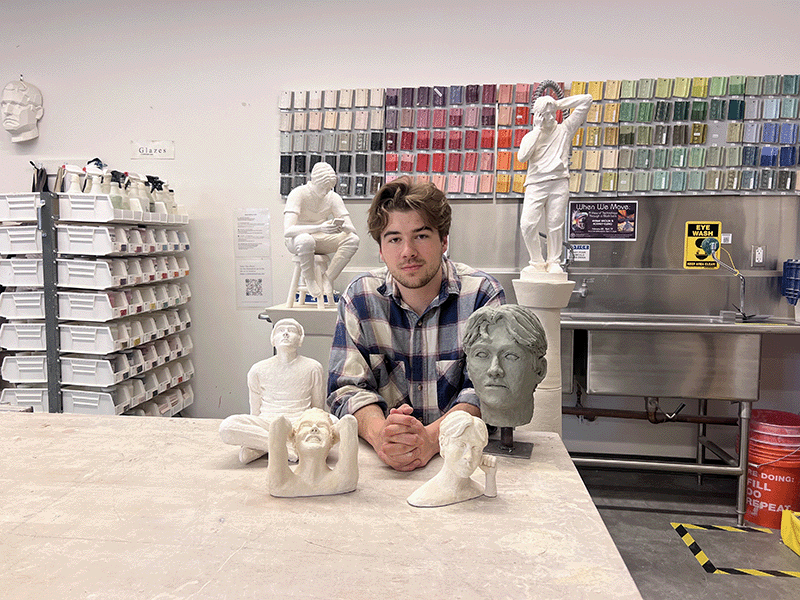 Charles DiNapoli in the sculpture studio next to a work table with his sculptures
