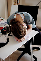 Young woman with her head down on her desk