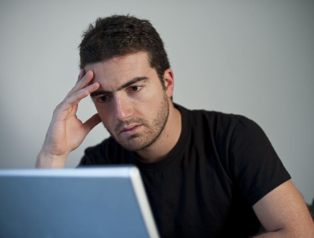 Man looking frustrated at the computer
