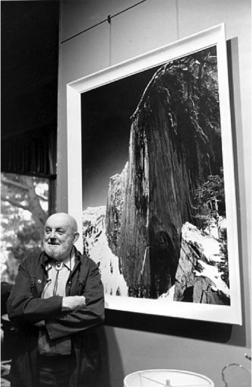 Ansel Adams standing in front of his photograph, 