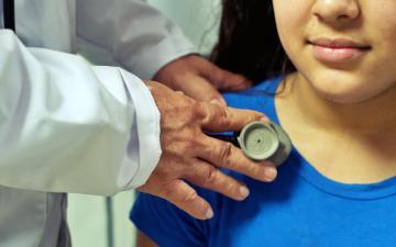 Girl in blue shirt being examined by medical doctor with stethoscope. Image by Julio César Velásquez Mejía from Pixabay.