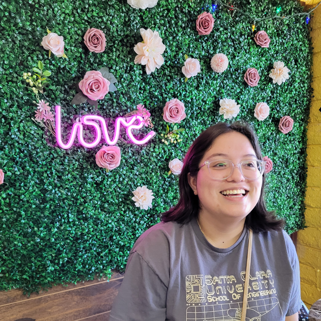 A student in front of a flower wall 