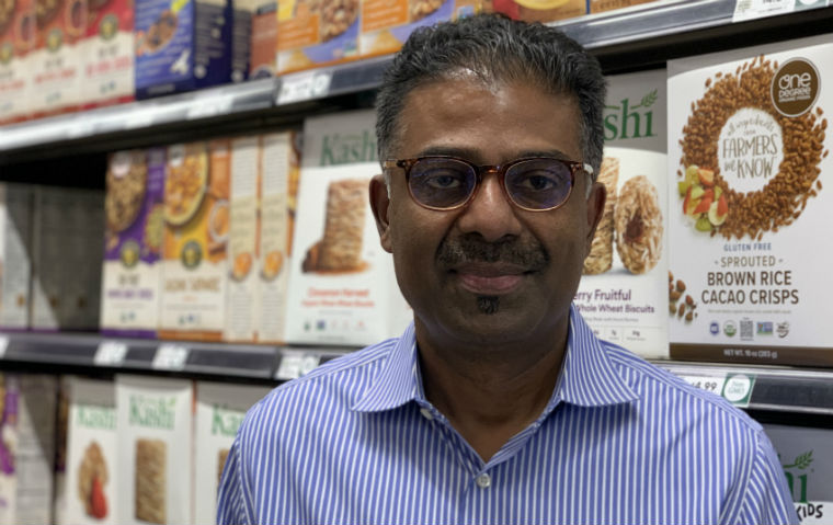 Prof. Kirthi Kalyanam poses in front of Whole Foods merchandise
