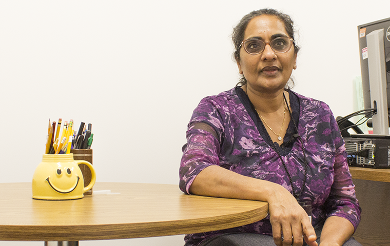 Professor Shoba Krishnan sits at the small round table where she meets with students one-on-one.