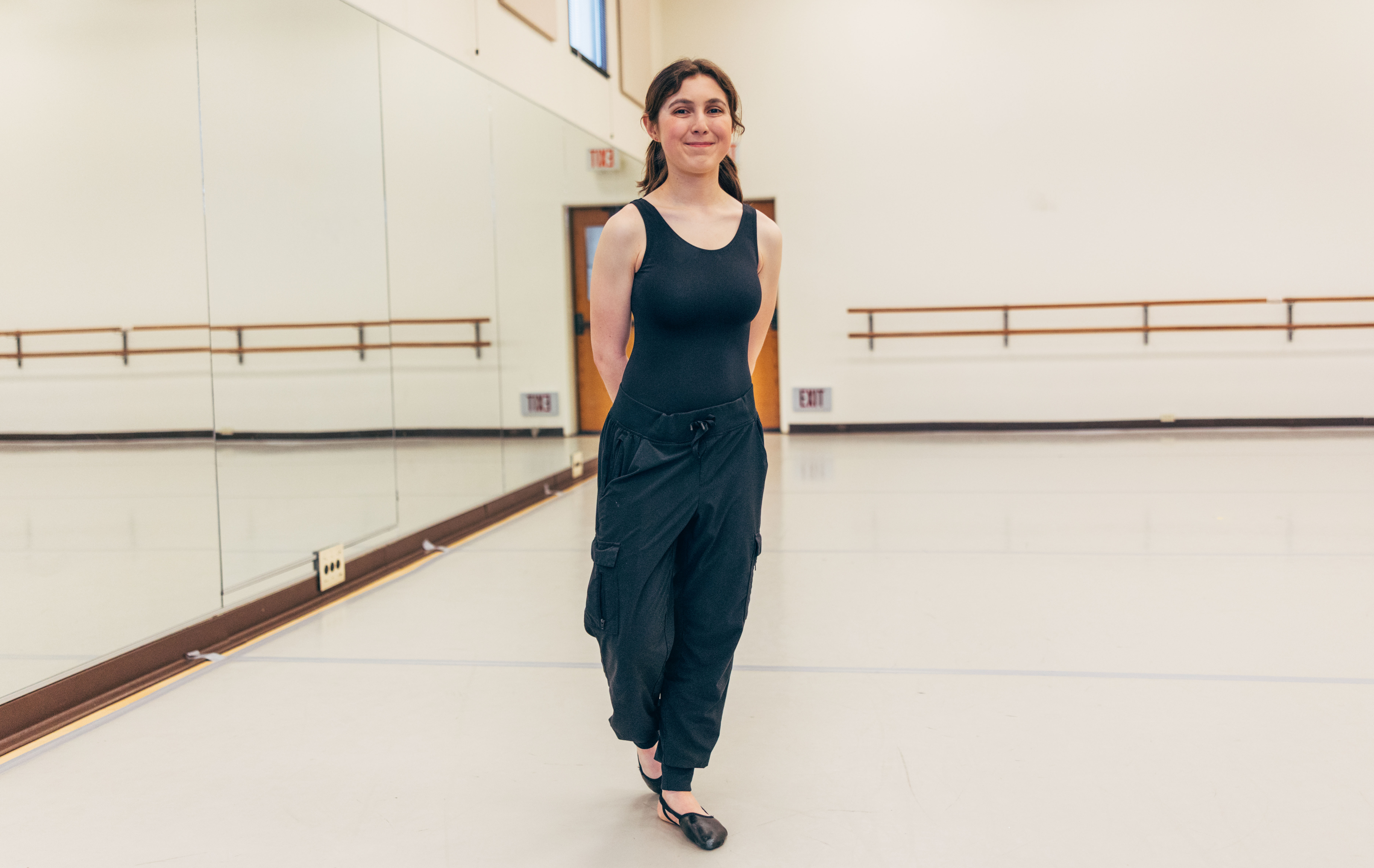 Female student poses in dance studio.