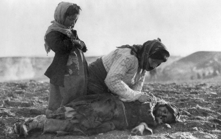 An Armenian woman and young girl check on the fallen body of another young girl.