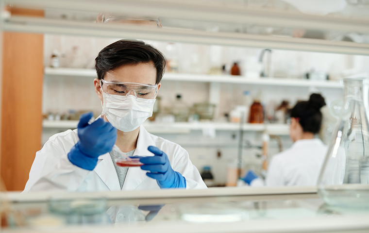 Man with mask and gloves in biotech lab