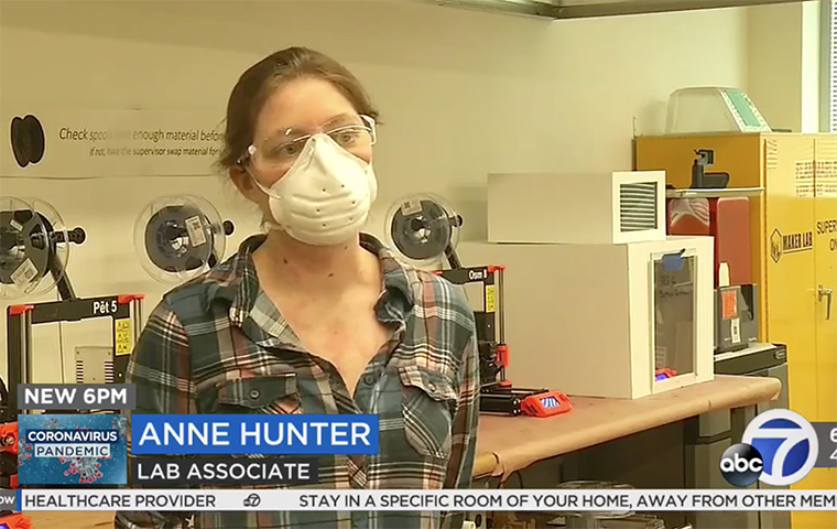 Anne Hunter speaks to camera in front of 3-D printers