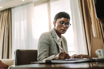 Picture of a black woman in a suit at a desk