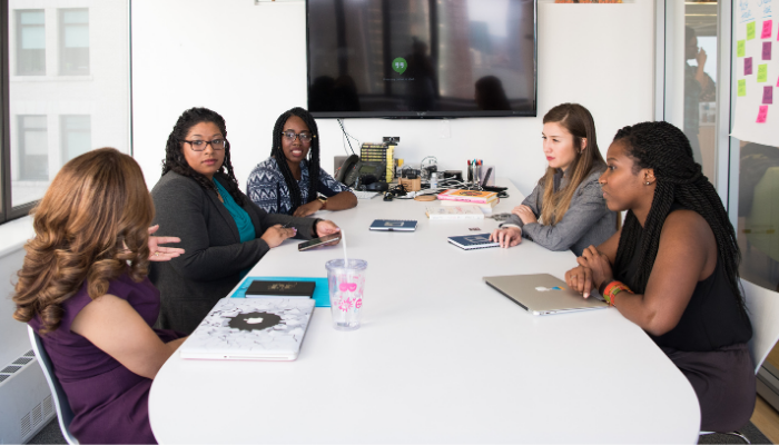 Picture of multiracial group of women sitting at a conference table