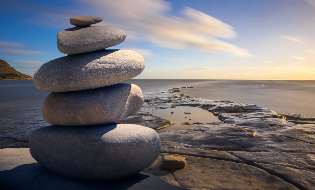 stacked rocks with ocean and sky in background