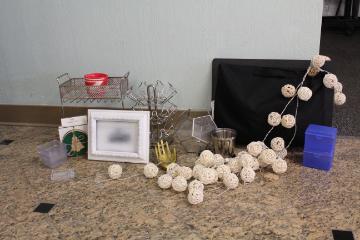 Collection of miscellaneous room supplies and decor including small containers, decorative accents, and a picture frame