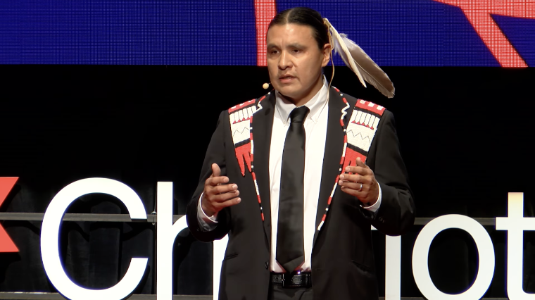 Close-up of speaker Chase Iron Eyes presenting on stage at the TEDx event