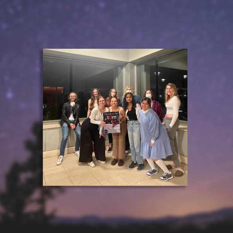 Photo of a group of smiling students with a night sky in the background