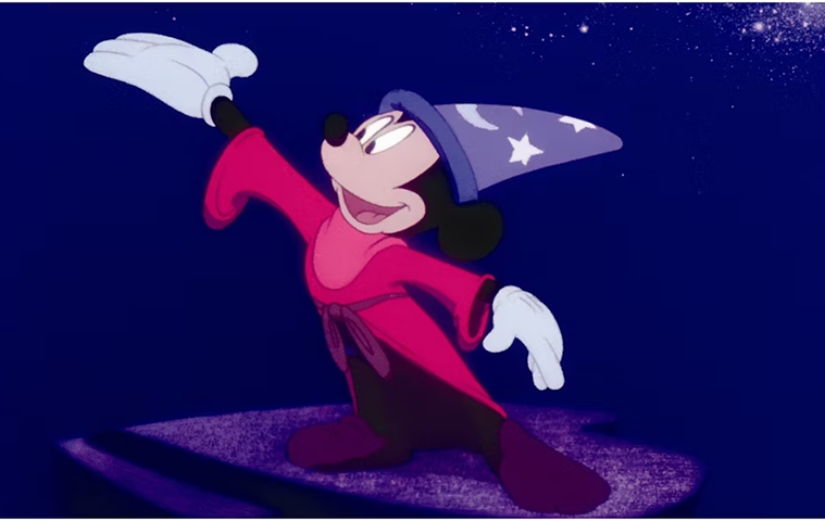 An animated mouse in a wizard robe and hat, waving his gloved hands.