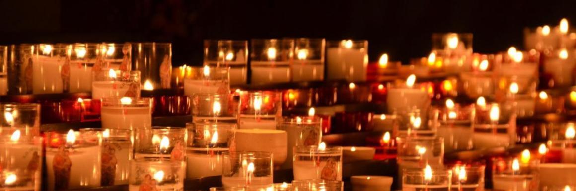 Photograph of votive candles lit inside a church 