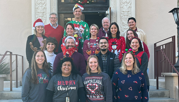 Group of people wearing holiday sweaters.