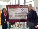 Jesica S. Fernandez with Professor/Dr. Cath Larkins (University of Lancashire, UK) standing next to a conference poster