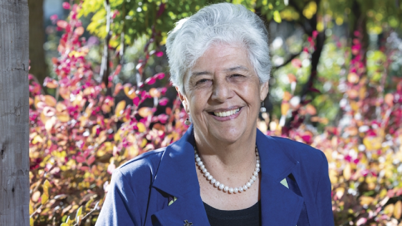 A smiling older woman in business wear.