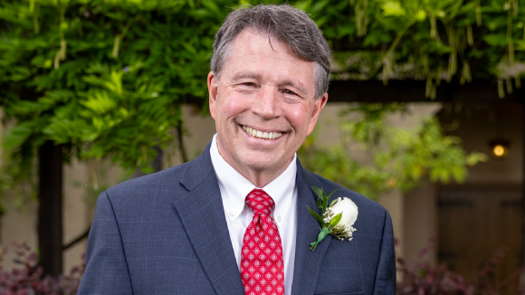 A smiling man in a suit and tie.