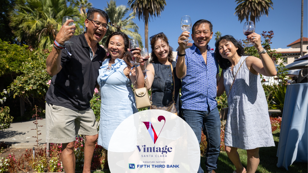 A group of people in dressy summer casual clothing, making a cheers motion towards the camera with their wine glasses. Overlaid text includes Santa Clara Universitys Vintage Santa Clara logo and underneath that Signature Partner, Fifth Third Bank.