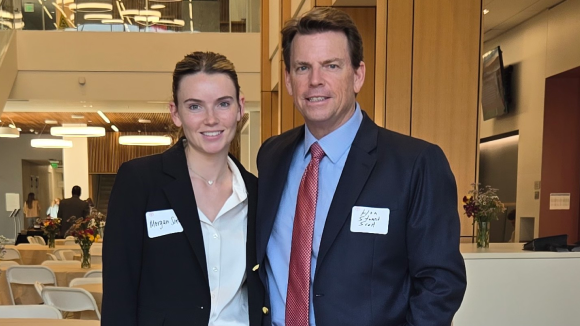 A man and a young woman in business wear standing together. The mans nametag reads Hon. Stuart Scott and the young womans reads Morgan Scott.