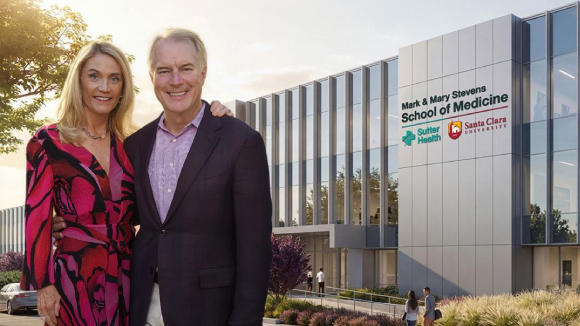 A man and a woman in business wear, standing in front of a mockup of a building labeled Mark and Mary Stevens School of Medicine. Sutter Health. Santa Clara University.
