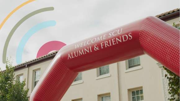 A red inflatable arch reading Welcome SCU Alumni & Friends in front of SCUs Bannan Alumni House
