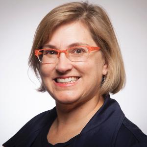 woman in orange glasses smiles in portrait