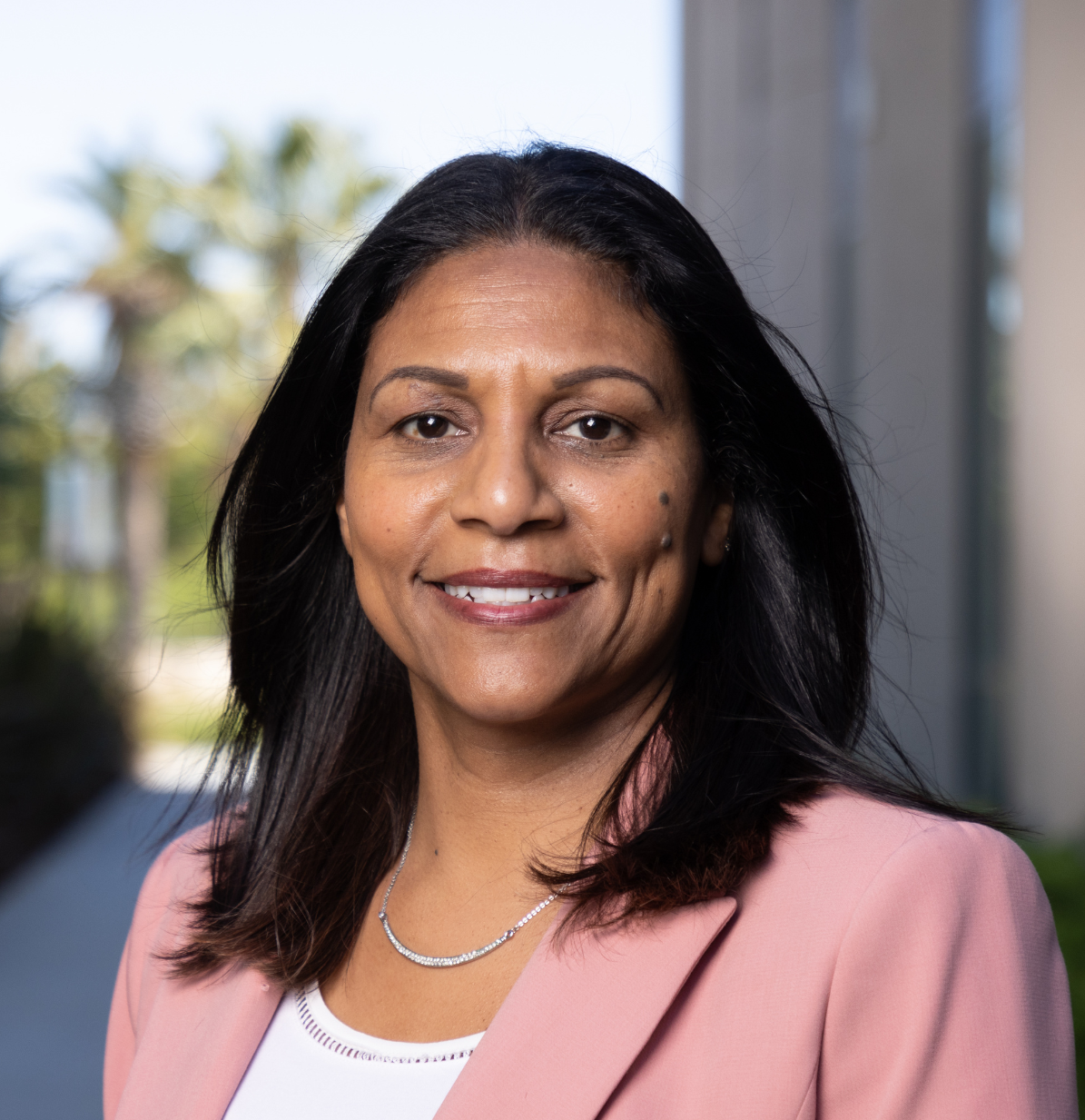 Woman in pink jacket smiles at camera