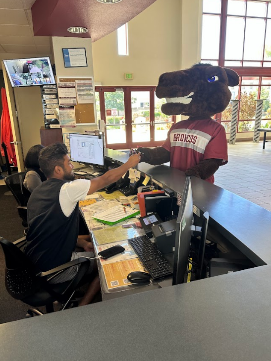 Bucky the Bronco giving his access card to the Malley Canter Front Desk