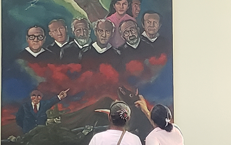 Visitors take in a powerful mural depicting the eight victims of the Nov. 16, 1989 massacre.
