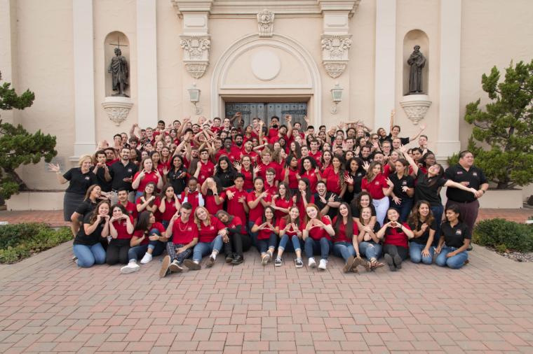 Large group of students representing Residential Learning Community pose for a picture in front of the Mission Church 