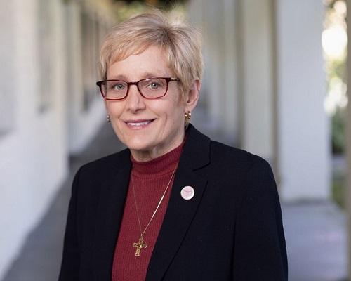 President Sullivan in a dark blazer and burgundy blouse. 