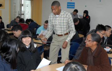 A teacher interacts with students in a classroom setting.