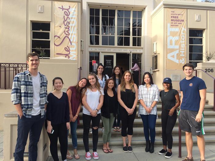 A group of students stands in front of a building. image link to story