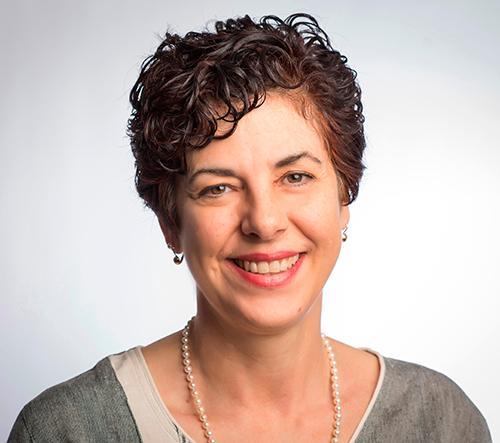 A person smiling with a neutral background. image link to story