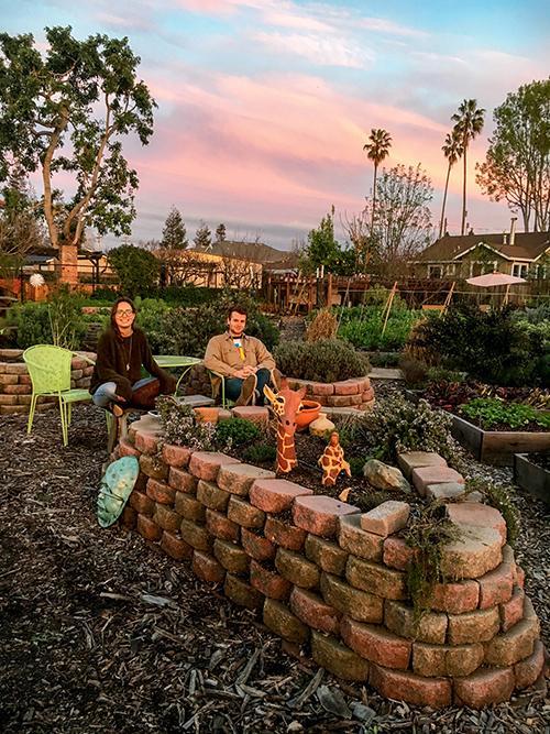 Garden with artistic elements under a colorful sunset, titled 'Student Spotlight.' image link to story