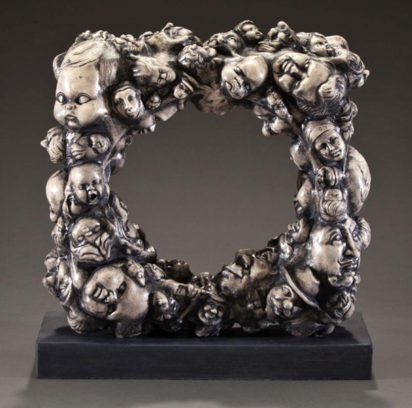 A square sculpture with intricate, detailed faces and figures by Pancho Jimenez. image link to story