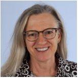 A person with glasses smiling in a patterned top. image link to story