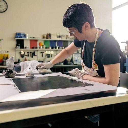 Person working with art supplies in a well-lit room. image link to story