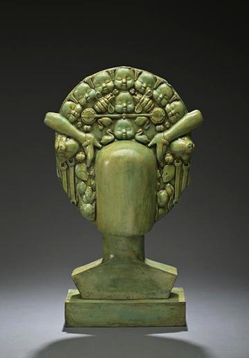 Green sculpture from Pancho Jimenez Exhibit featuring a bust with a detailed decorative headpiece. image link to story