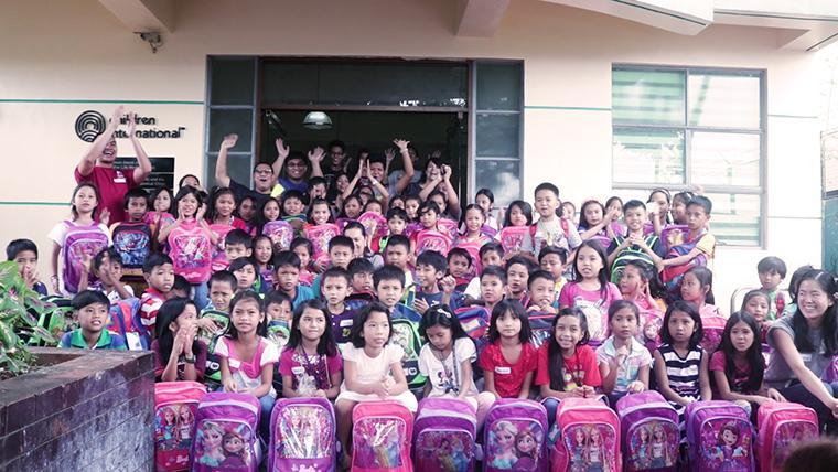 A group shot of students with their new backpacks.