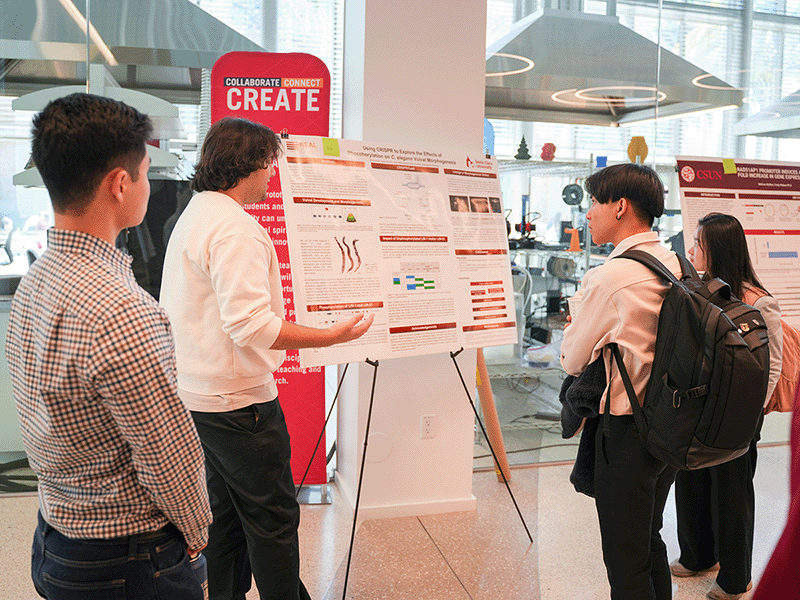 An SCU student explains his poster to other students