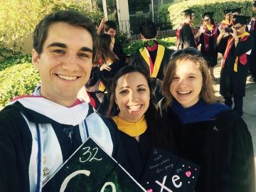 Three graduates in caps and gowns, one holding a decorated cap with 'Class of 2016'.