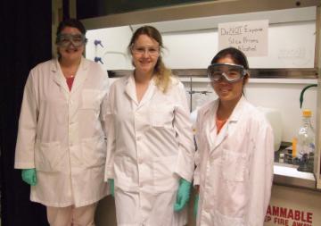 Three people in lab coats in Stokes Lab. image link to story