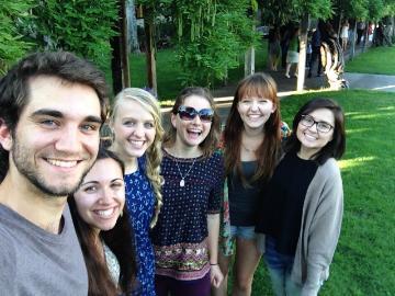 Group of six people smiling outdoors near trees. image link to story