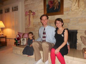 Two people sitting by a fireplace with Christmas decorations. image link to story