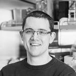 A person in a kitchen, wearing glasses and a dark sweater. image link to story