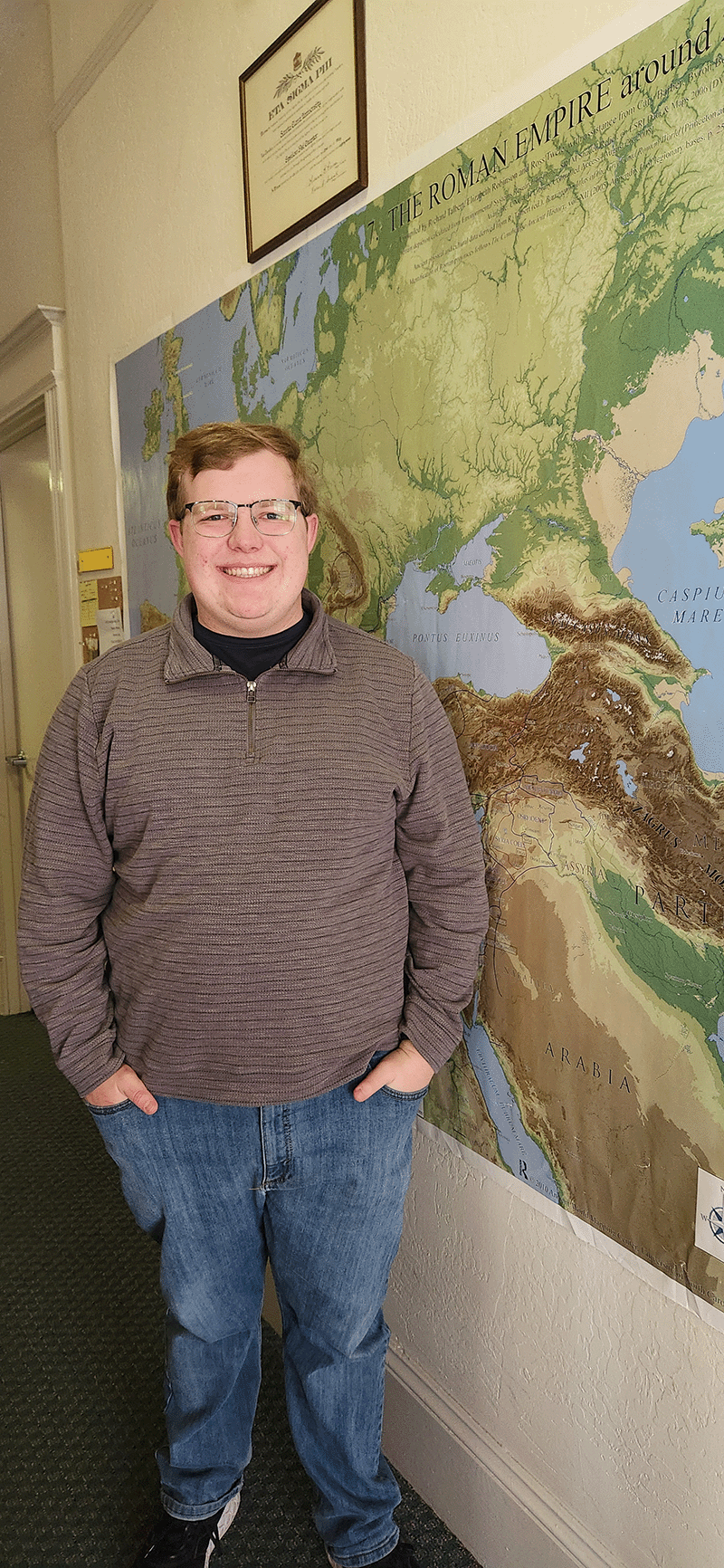 Sean Hayden standing next to a map